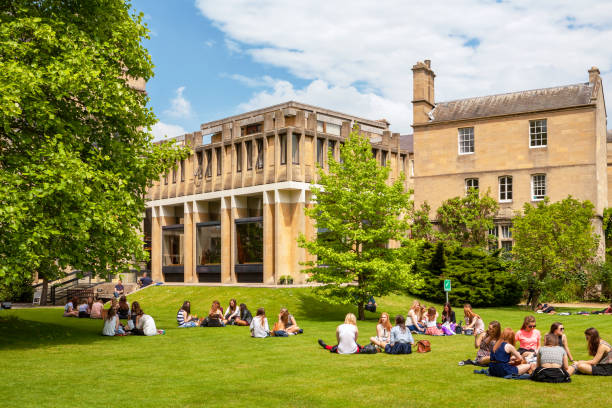 Students relaxing on the lawn in front of a historic UK university building
